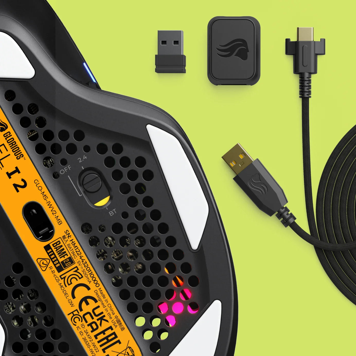 Bottom view of the Model I 2 Wireless in Black showing the sensor, feet, and placed next to the charging cable and wireless dongle